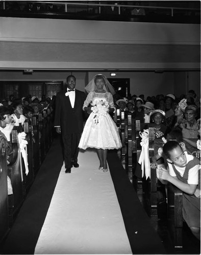 Lois C. Williams walking down the aisle during her wedding at Second Baptist Church, Los Angeles, 1962