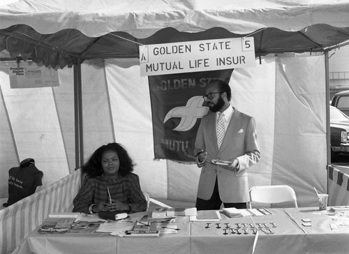 Black Agenda Business Fair participants standing in their booth, Los Angeles, 1983