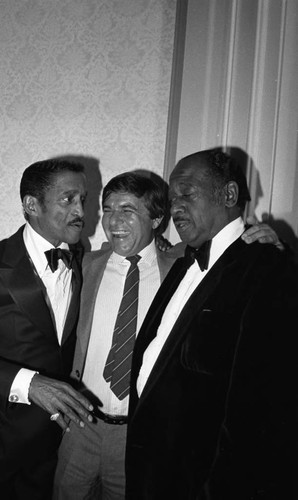 Sammy Davis Jr. talking with others at a formal event, Los Angeles, 1983