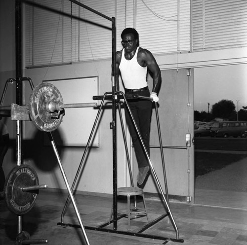 Man exercising in the Compton College gym, Compton, 1972