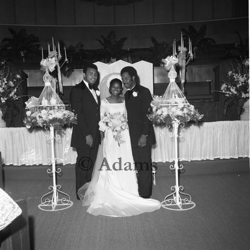 Muhammad Ali posing with Howard Bingham and Carolyn Turner at their wedding, Los Angeles, 1972