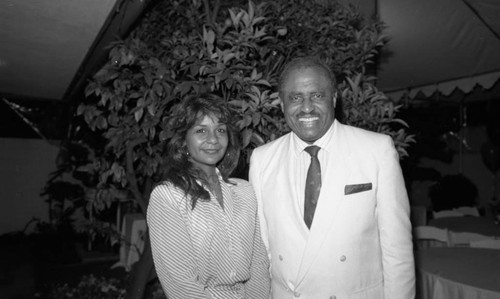 Eddie Robinson posing with a woman during a Los Angeles Football Classic promotional event, 1989