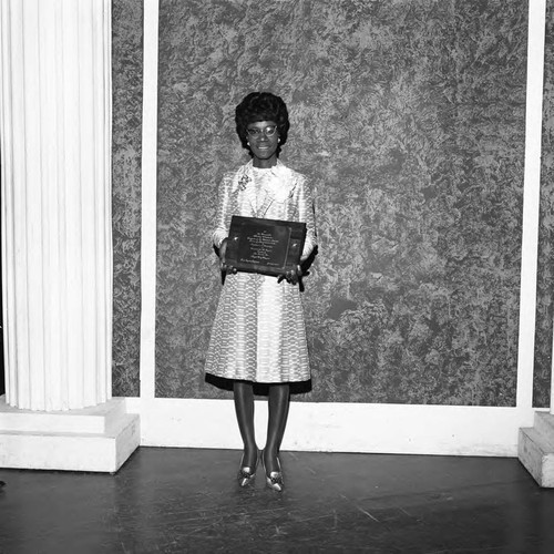 Shirley Chisholm holding a plaque awarded by Angels City Links, Los Angeles, 1970