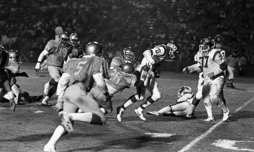 Dorsey and Locke High School football teams running a play during a city championship game, Los Angeles, 1982