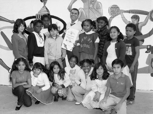 Bernard Hoyes posing with school children in front of a mural, Los Angeles, 1984