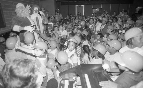 Children surrounding Santa and Ronald McDonald at a Dodgers Christmas party, Los Angeles, 1982