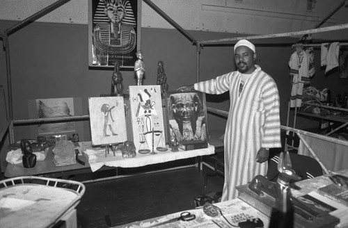 Man exhibiting items in his booth during the annual African festival, Los Angeles, 1986