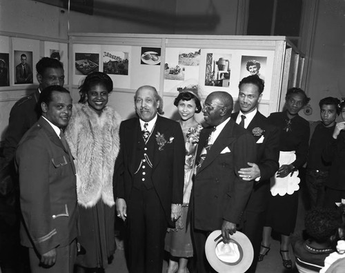 Bishop Charles Manuel "Sweet Daddy" Grace posing with others at the California School of Photography Open House, Los Angeles, 1950