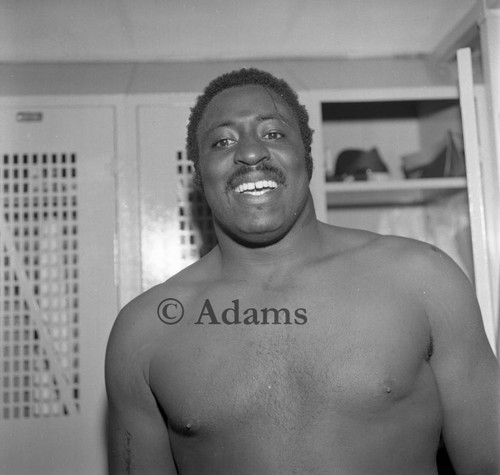 Football player in locker room, Los Angeles, 1973