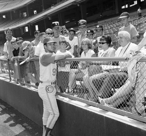 Reggie Jackson talking with people in the stands at Anaheim Stadium, Los Angeles, 1969