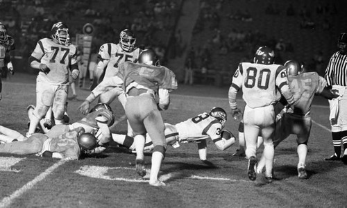 Dorsey and Locke High School football teams running a play during a city championship game, Los Angeles, 1982