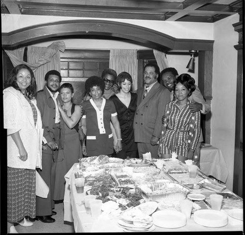 Dinner party attendees posing around a table, Los Angeles, 1971