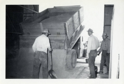 3 men behind dump truck