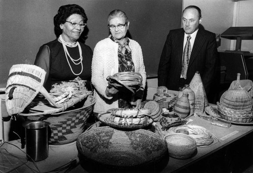 Three people examining baskets