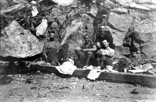 Railroad construction men seated in Feather River Canyon