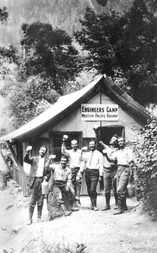 Railroad construction workers posing in front of tent