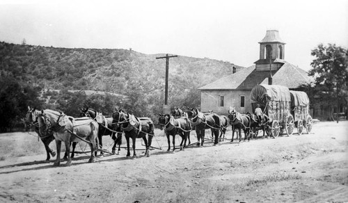 Covered wagon in front of school house