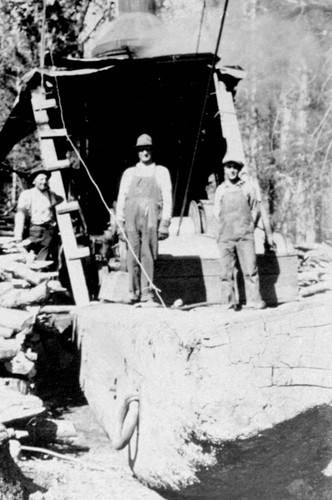 Crew members in front of Dolbeer donkey engine at Lyonsville