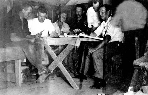 Railroad construction workers seated at table in tent