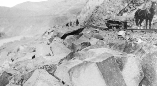 Boulders piled along rail bed during railroad construction on the Feather River