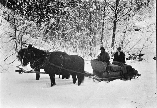 Couple Sledding Through Snow