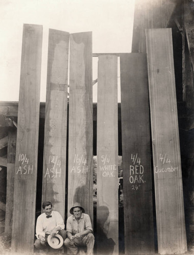 N. P. Wheeler and another man posed before samples of milled planks