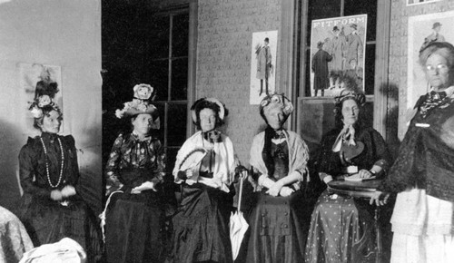 Women seated wearing what appear to be costumes
