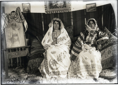 Two women in Arab costume seated in the crew house