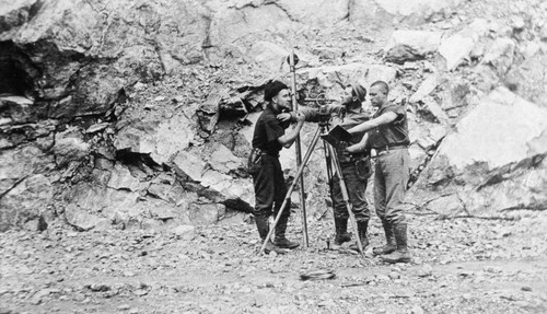 Railroad construction workers posing with surveying equipment