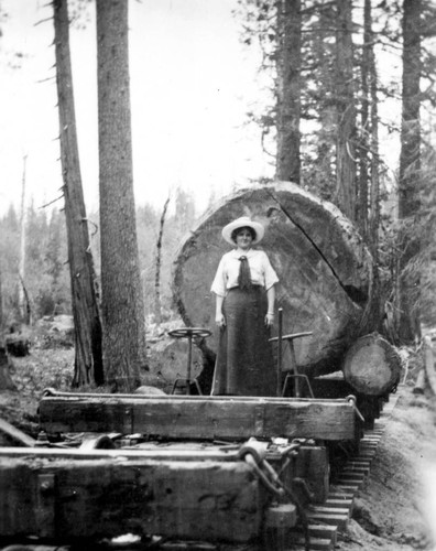 Woman Standing on Diamond Rail Car with Large Log