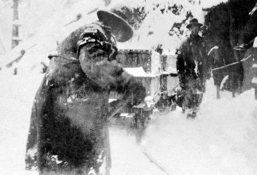 Man digging snow near tunnel