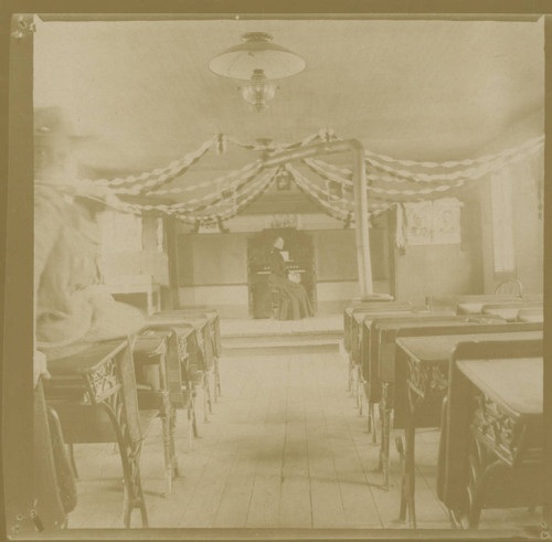 Teacher at organ in old classroom