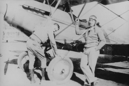 Two men standing by airplane