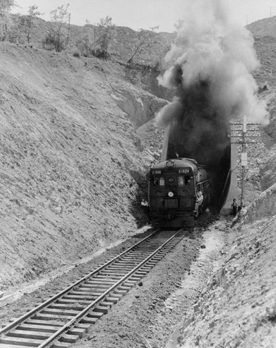 Train emerging from railroad bypass tunnel, Shasta Dam construction