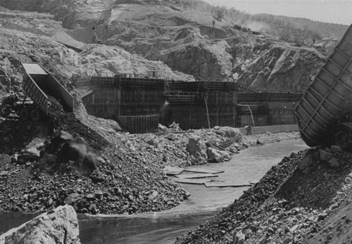 Placing material for cofferdam at Shasta Dam construction site