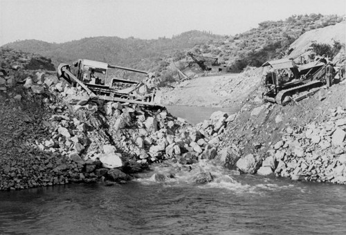 Placing material for cofferdam at Shasta Dam construction site