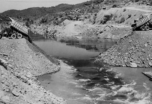 Placing material for cofferdam at Shasta Dam construction site