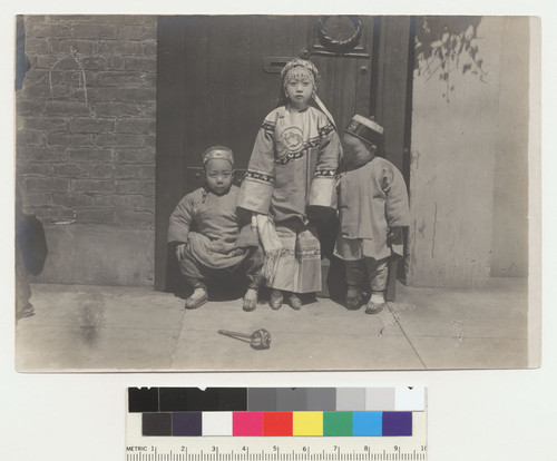 [two boys with older girl in doorway]