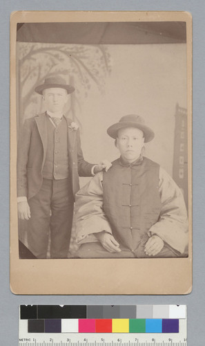 [portrait of white young man posing with seated Chinese man]