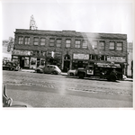 East side of Broadway between 9th and 10th Streets in downtown Oakland, California. Oakland Pharmacy, Uncle Sam's Loans, Merit Hatters, Syrian Importing Co. in view