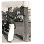 Man demonstrates how to operate a fire-alarm box, numbered 3551, in Oakland, California