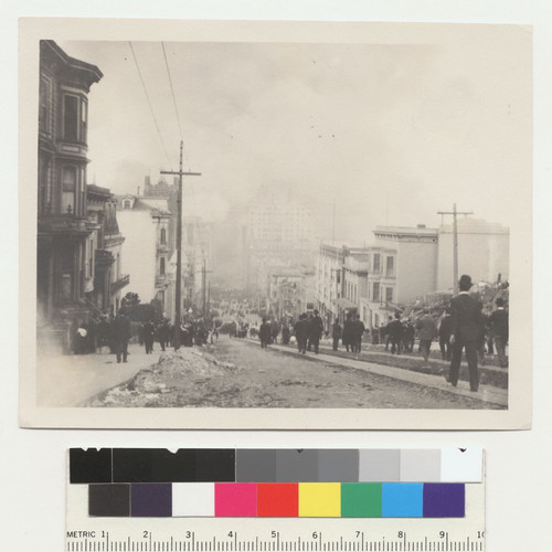 [Crowds gathered along California St. watching fire burn in distance.]