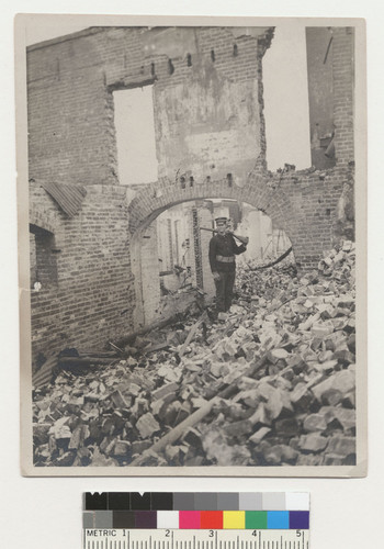 [Soldier posing among ruins. Unidentified location.]