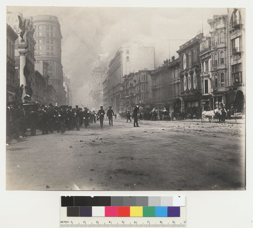 Before fire. [Police patroling Market St. as fire approaches. Between Fifth and Sixth Sts. Flood Building, left; Call Building in distance, left center; Emporium department store, center.]