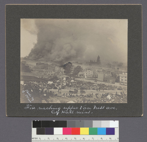 Fire reaching upper Van Ness Ave. City Hall ruins. [verso:] The fire reaching St. Mary's Cathedral on upper Van Ness Ave. (shown on the extreme left, ruins of City Hall towards the center) on the afternoon of second day of the fire Apr. 19th 06. 1st in series of three panoramic views showing the line of fire that aft. [Taken from above Market and Buchanan Sts.]