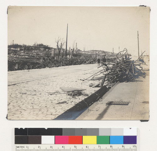 [Unidentified street lined with scrap metal.]