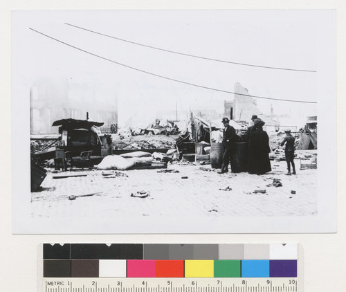 [Refugees with belongings among ruins. Unidentified location.]