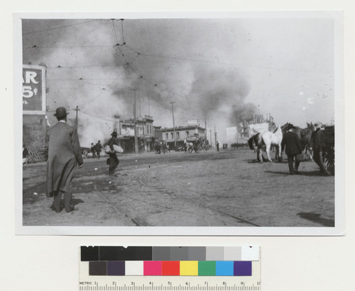 [Street scene showing fire burning in distance. Near Ferry Building? From near same location as FN-11940.]