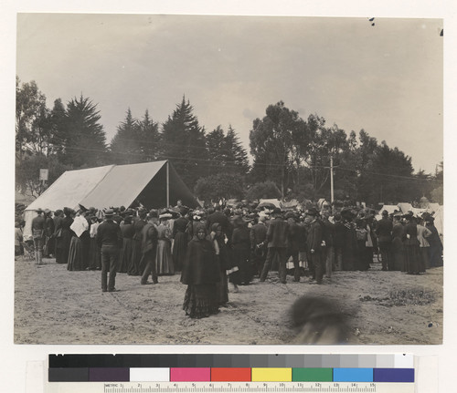 [Refugees gathered at tent. Unidentified camp.]