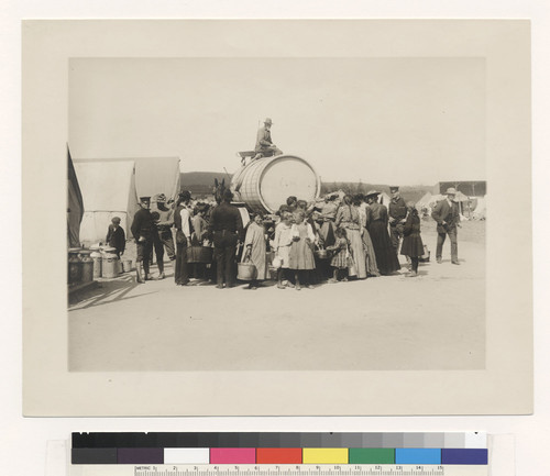 [Refugees gathered around water wagon.]